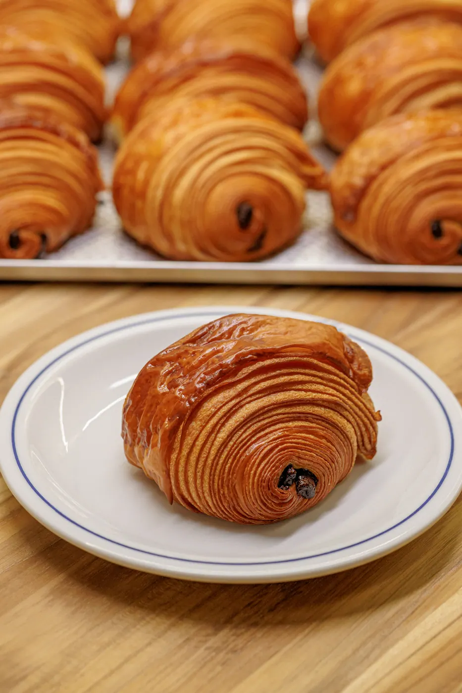 Pain au chocolat folhado e brilhante ao lado de croissants
