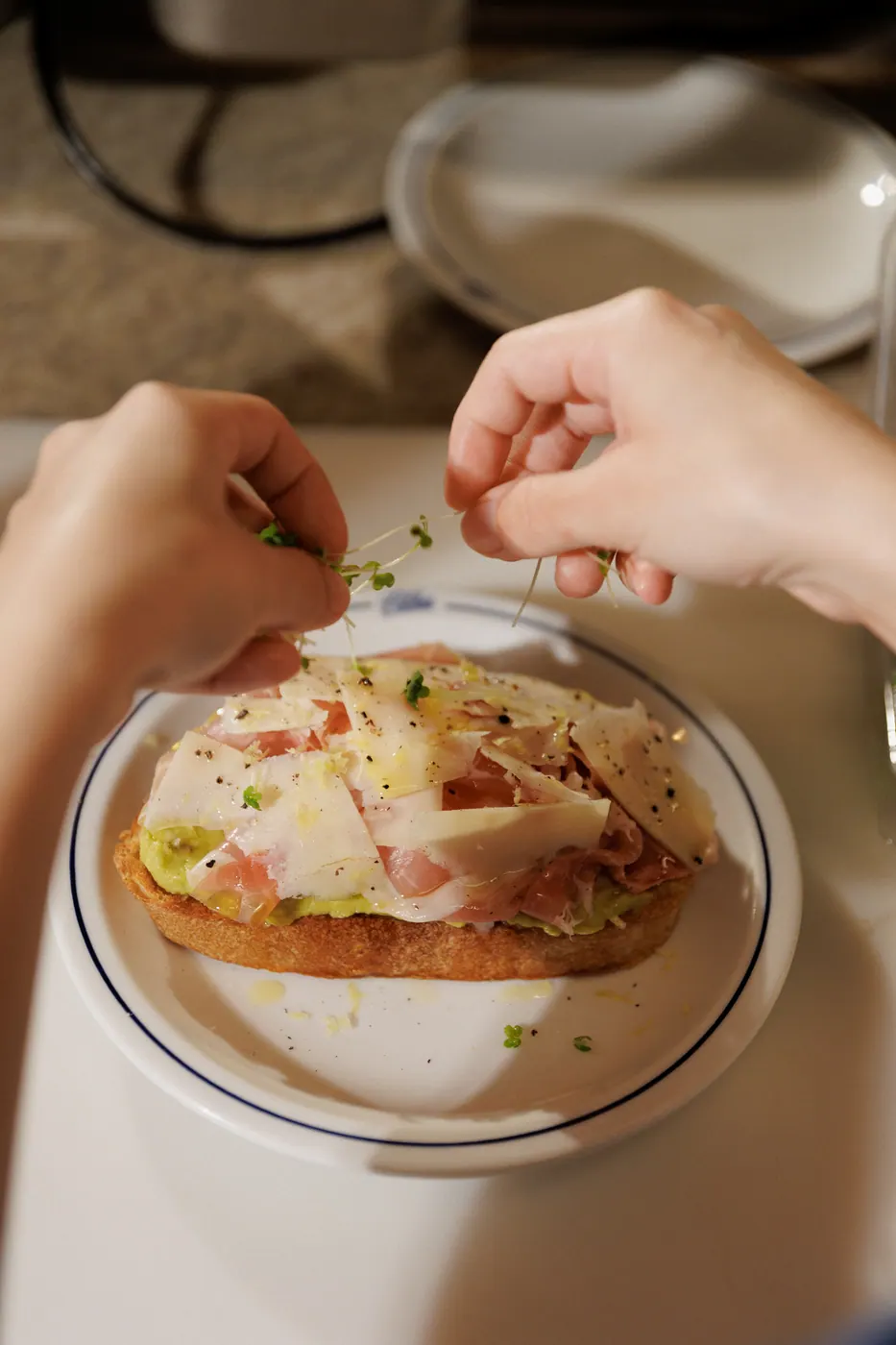 Finalização de tartine com brotos frescos