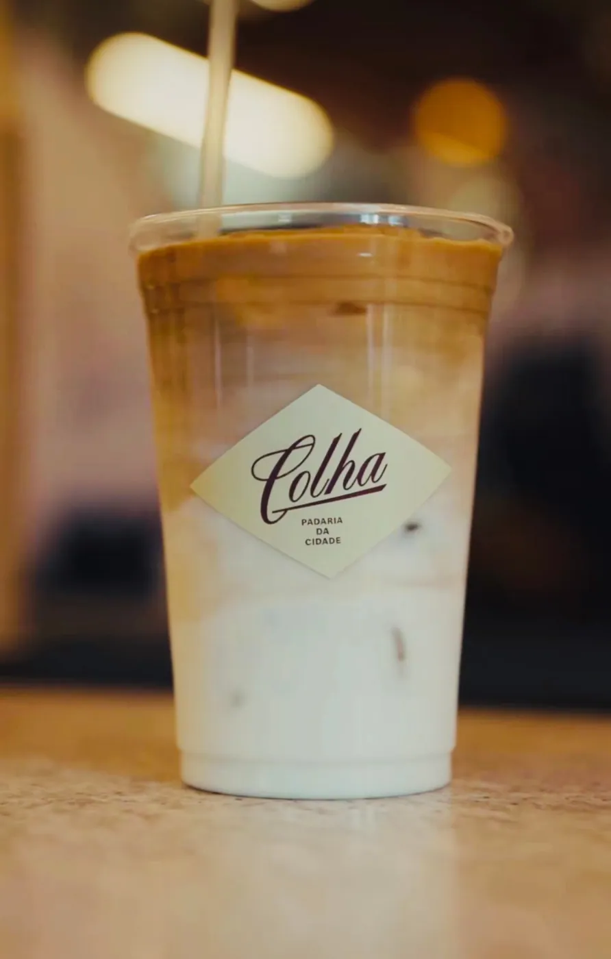 Vanilla latte gelado em copo da Colha com o selo losango